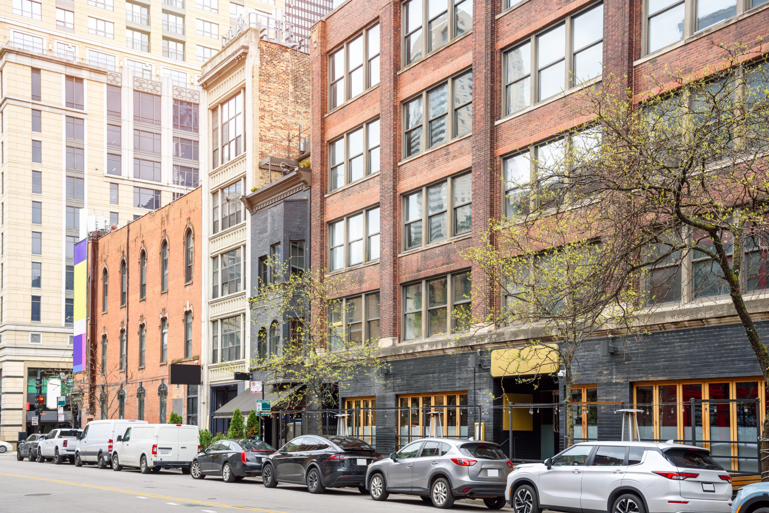 Row of Renovated traditional brick buildings with shop and restaurants on the ground level along a street in downtown Chicago. Illinois, USA.